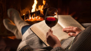 wine and book near fireplace